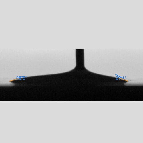 Low contact angle measurement of a spread droplet, showing left angle of approximately 28.5° and right angle of approximately 20.4°, indicating a hydrophilic surface